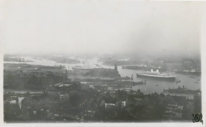 Blick vom „Michel“ (Hamburger Hauptkirche) auf den Hafen, die Lagerhäuser der neuen Speicherstadt stehen bereits (mittig links), zwei große Dampfschiffe fahren auf der Elbe ein (Foto: 1929; Scan, Privatbesitz Robert Matthees, optimiert mit Remini AI).