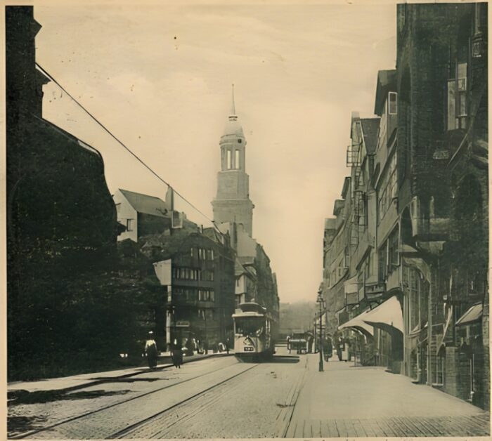 Große Michaelisstraße, Blick vom kleinen, katholischen "Michel" (vorn links im Schatten) zum großen evangelischen "Michel" (Hamburger Hauptkirche), Postkarte, Hamburg, ca. 1900 (optimiert mit Remini AI).